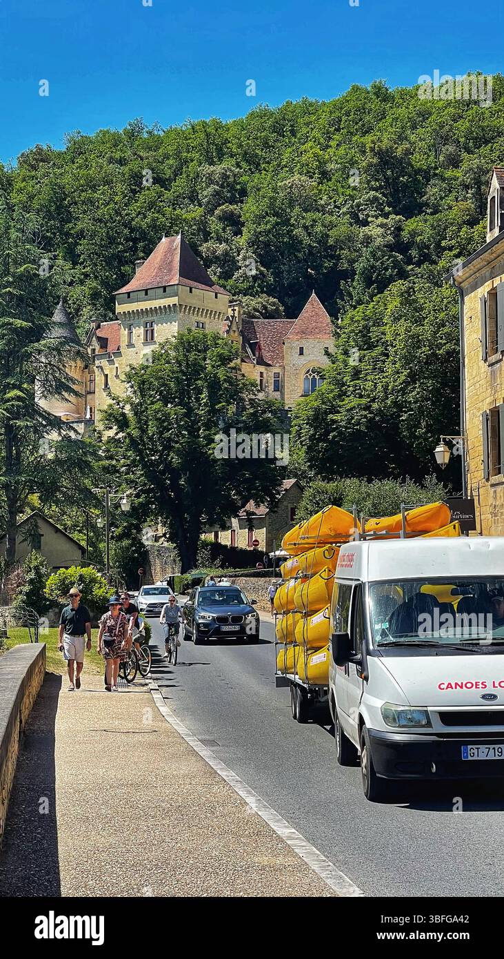 Ein weißer Minibus bringt Touristen-Kajaks durch das charmante französische Dorf La Roque-Gageac, bereit für Abenteuer auf der Dordogne, Frankreich Stockfoto