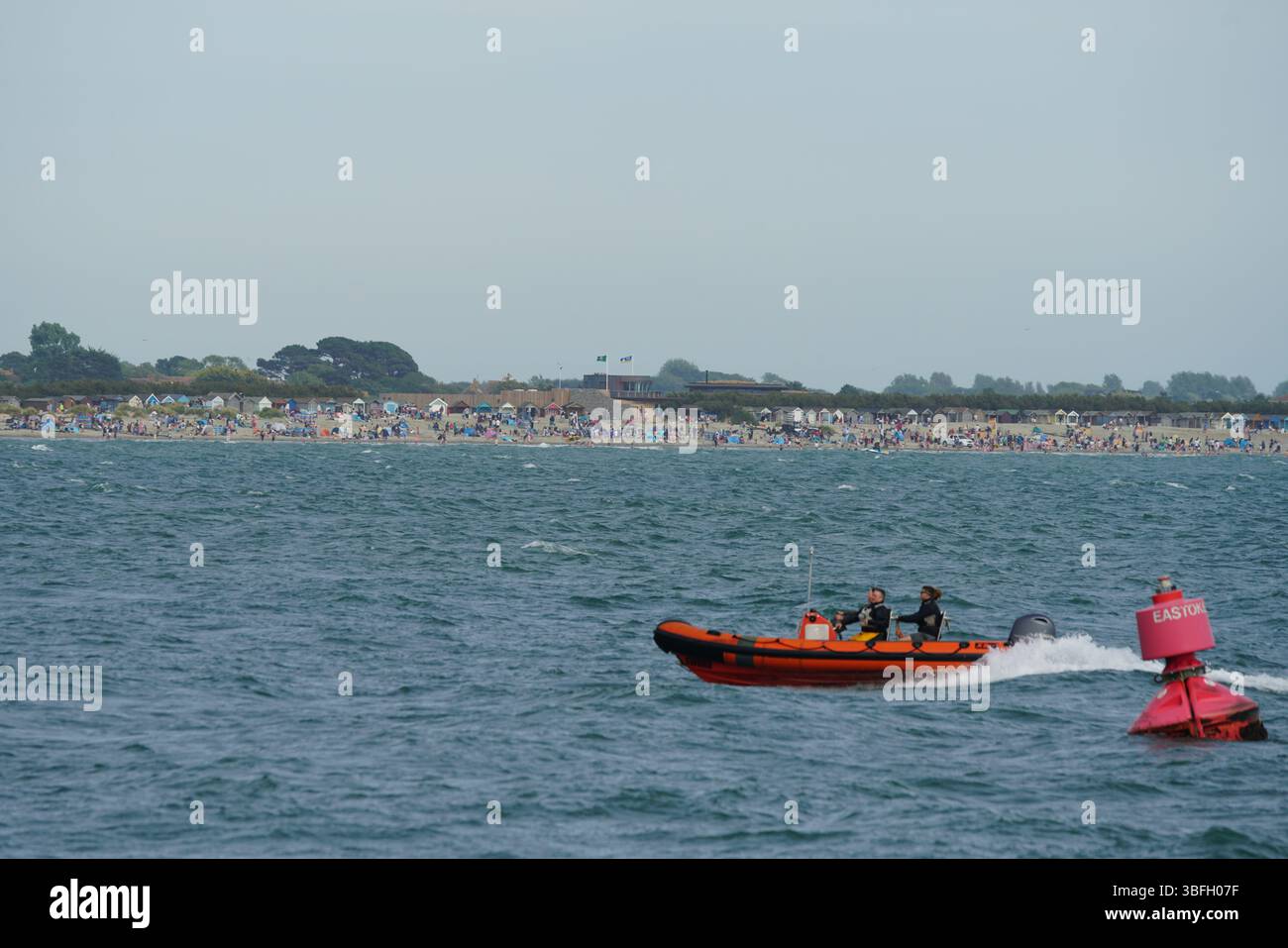 Rettungsschwimmer patrouillieren in der Nähe des überfüllten Strandes an einem angenehmen Tag. Hayling Island, Großbritannien Stockfoto