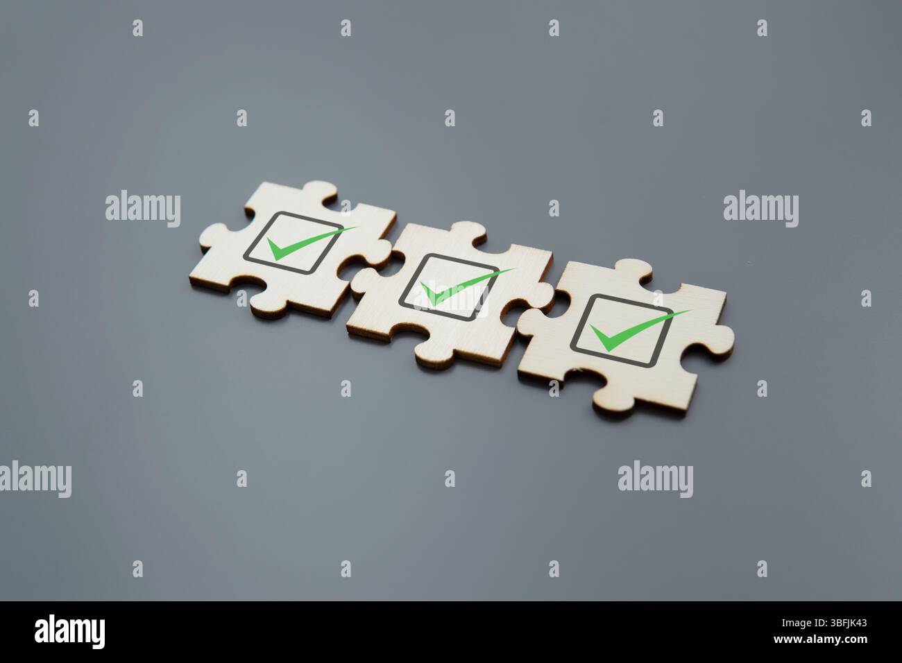 Puzzleteile mit einem grünen Häkchen. Validierung, Checkliste, geprüft, Genehmigungskonzept. Stockfoto