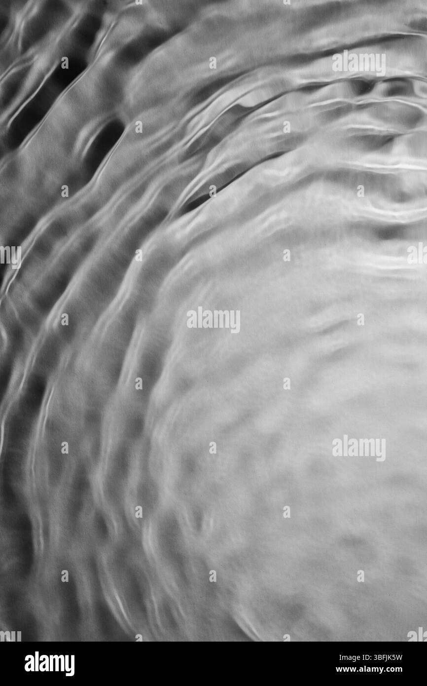 Die Wasseroberfläche wackelt und erzeugt ein abstraktes Schwarz-weiß-Muster Stockfoto