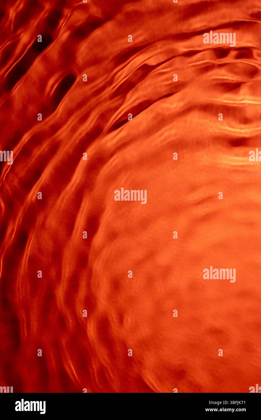 Leuchtend orange Wasseroberfläche für atemberaubende abstrakte Muster Stockfoto