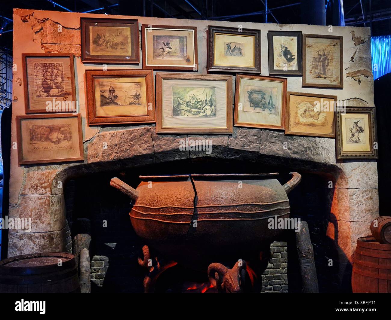 Vintage-Kamin mit Kessel umgeben von gerahmten Kunstwerken Stockfoto