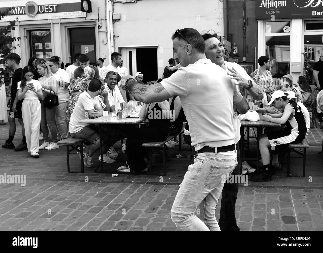 Paare tanzen auf der Straße während der Feierlichkeiten am 1. Mai La Fête du Muguet (Tag der Lilly des Tals) am Tag der Arbeit in Guines in Nordfrankreich 2025 Stockfoto