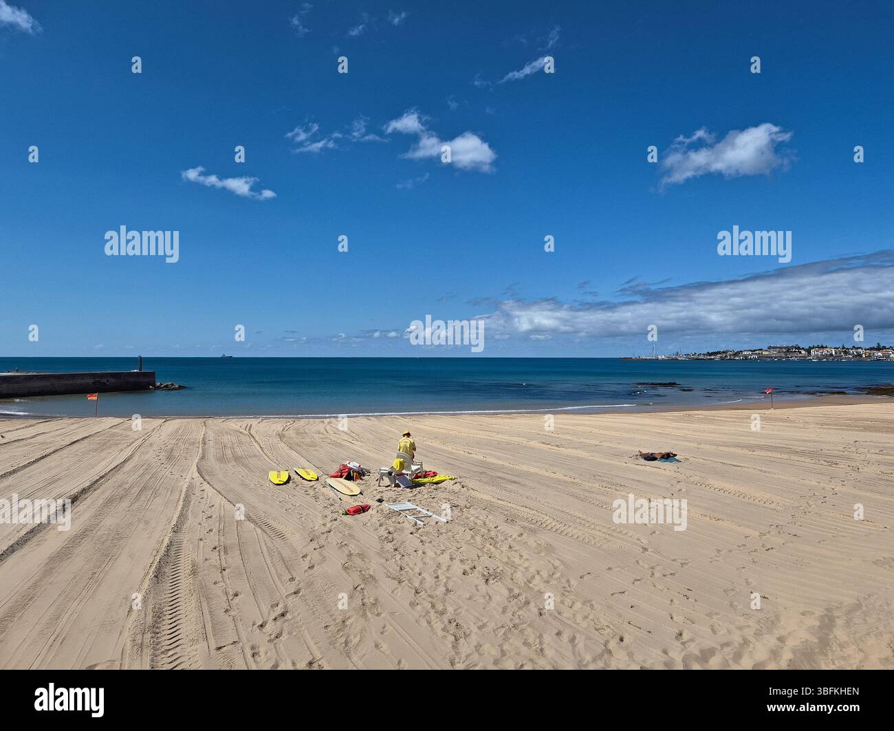 Estoril, Portugal - 15. Mai 2025: Ein einziger Rettungsschwimmer wurde an den ersten Tagen der Badesaison mit einem einzigen Sonnenbader am Strand von Estoril aufgestellt Stockfoto