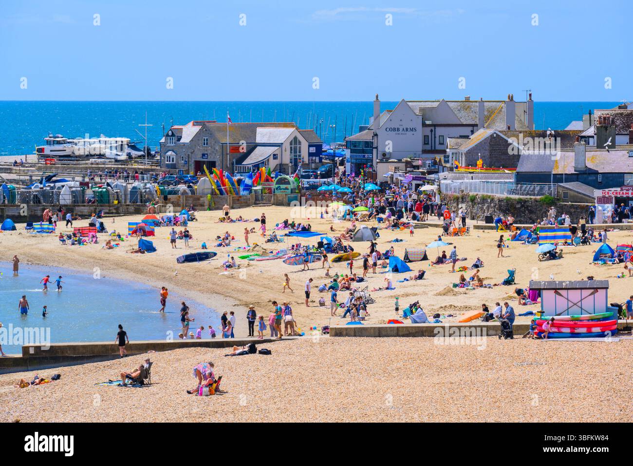 Lyme Regis, Dorset, Großbritannien. Juni 2025. Wetter in Großbritannien. Besucher und Einheimische genossen einen glorreichen, heißen und sonnigen Start in die Woche im malerischen Badeort Lyme Regis. Die Leute waren am Strand gespickt und sonnigen die Sonne, während andere am Meer entlang spazierten. The Credit: Celia McMahon/Alamy Live News Stockfoto