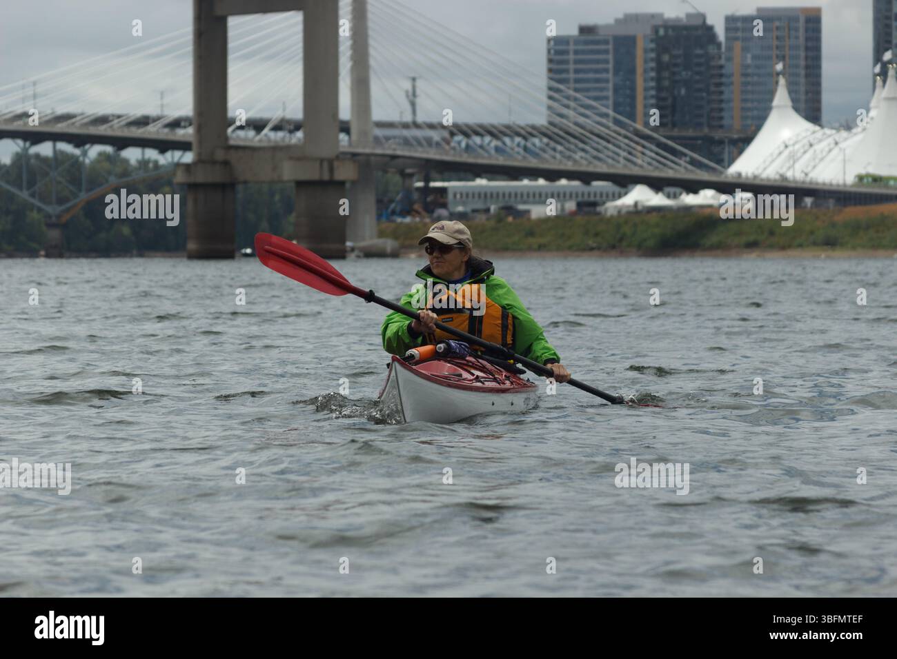 The Big Float, Portland, Oregon - 10. Juli 2016: Eine Frau fährt mit dem Kajak auf dem Willamette River und genießt die Veranstaltung und die Skyline der Stadt. Stockfoto
