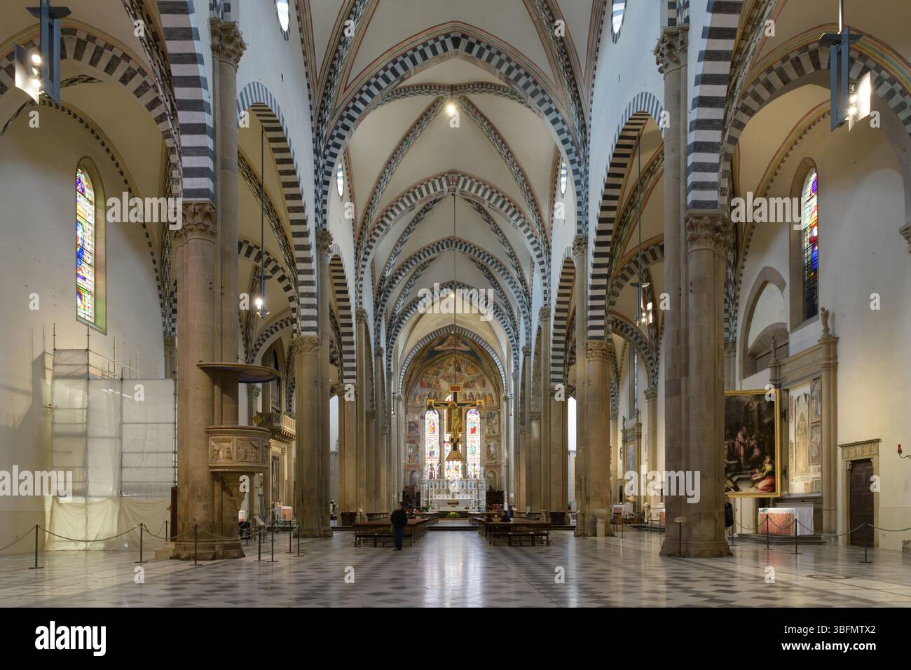 Innenansicht des Kirchenschiffs und der Apsis Santa Maria Novella in Florenz, Italien. Gotische Architektur mit Rippengewölben und gestreiften Marmorsäulen. Stockfoto
