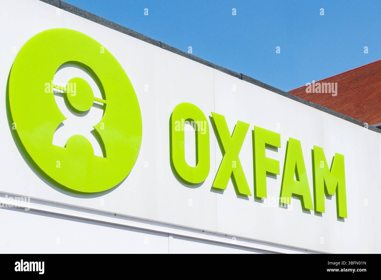 Nahaufnahme des Oxfam-Logos auf einer Gebäudefassade unter klarem blauem Himmel Stockfoto