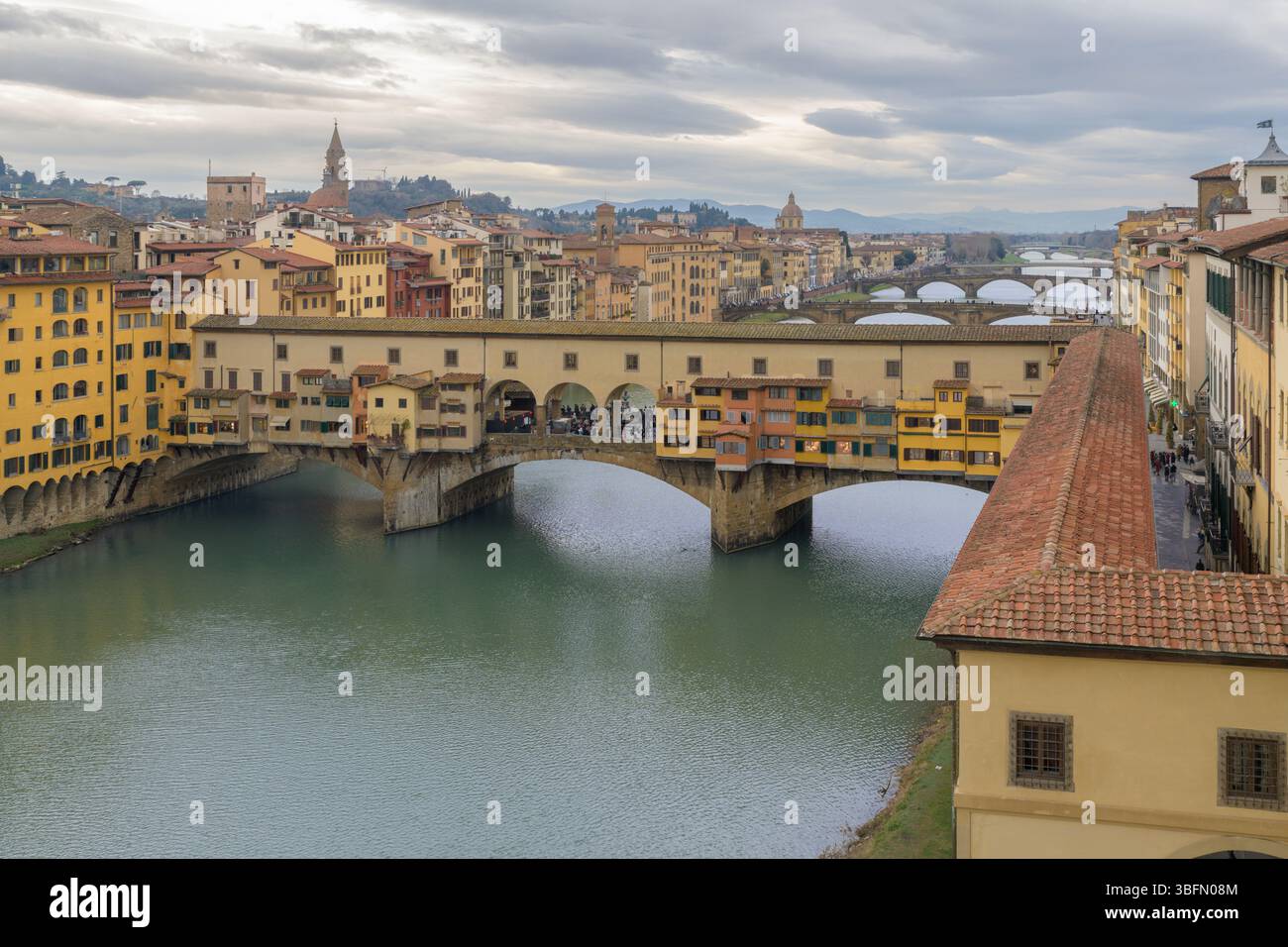 Panoramablick auf Ponte Vecchio über den Fluss Arno mit Vasari Korridor und farbenfrohen mittelalterlichen Gebäuden in Florenz, Italien. Stockfoto