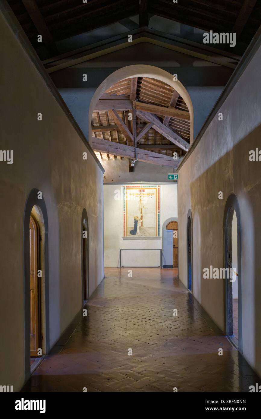 Blick auf den gewölbten Korridor im San Marco Kloster, Florenz, mit Fra Angelico Fresko des Heiligen Dominikus am Fuße des Kruzifix. Stockfoto Blick auf den gewölbten Korridor im San Marco Kloster, Florenz, mit Fra Angelico Fresko des Heiligen Dominikus am Fuße des Kruzifix. Stockfoto