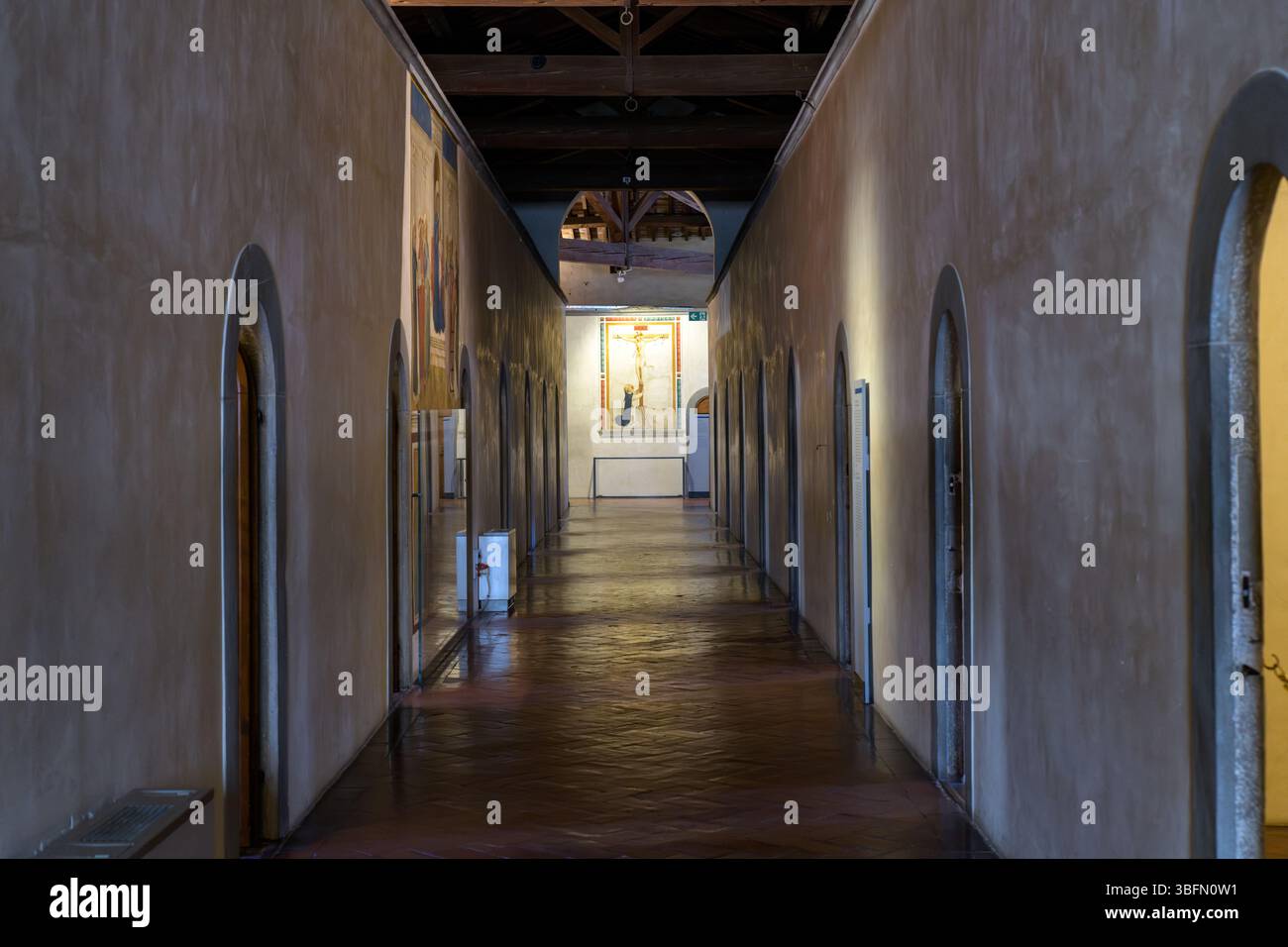 Blick auf den Korridor im Kloster San Marco, Florenz, mit Fra Angelico Fresko des Heiligen Dominikus am Fuße des Kreuzes an der anderen Mauer. Stockfoto Blick auf den Korridor im Kloster San Marco, Florenz, mit Fra Angelico Fresko des Heiligen Dominikus am Fuße des Kreuzes an der anderen Mauer. Stockfoto