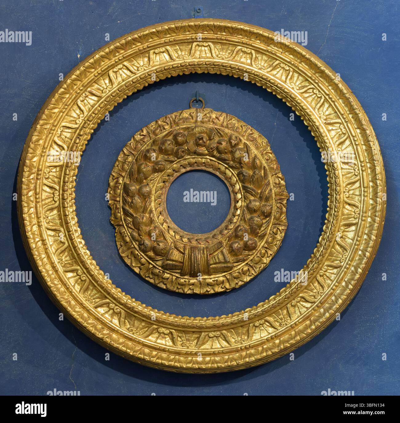 Zwei konzentrische runde vergoldete Holzrahmen mit kunstvoller Renaissance-Schnitzerei, einer mit Früchten und Bandkranz. Museo Stefano Bardini, Florenz, I Stockfoto