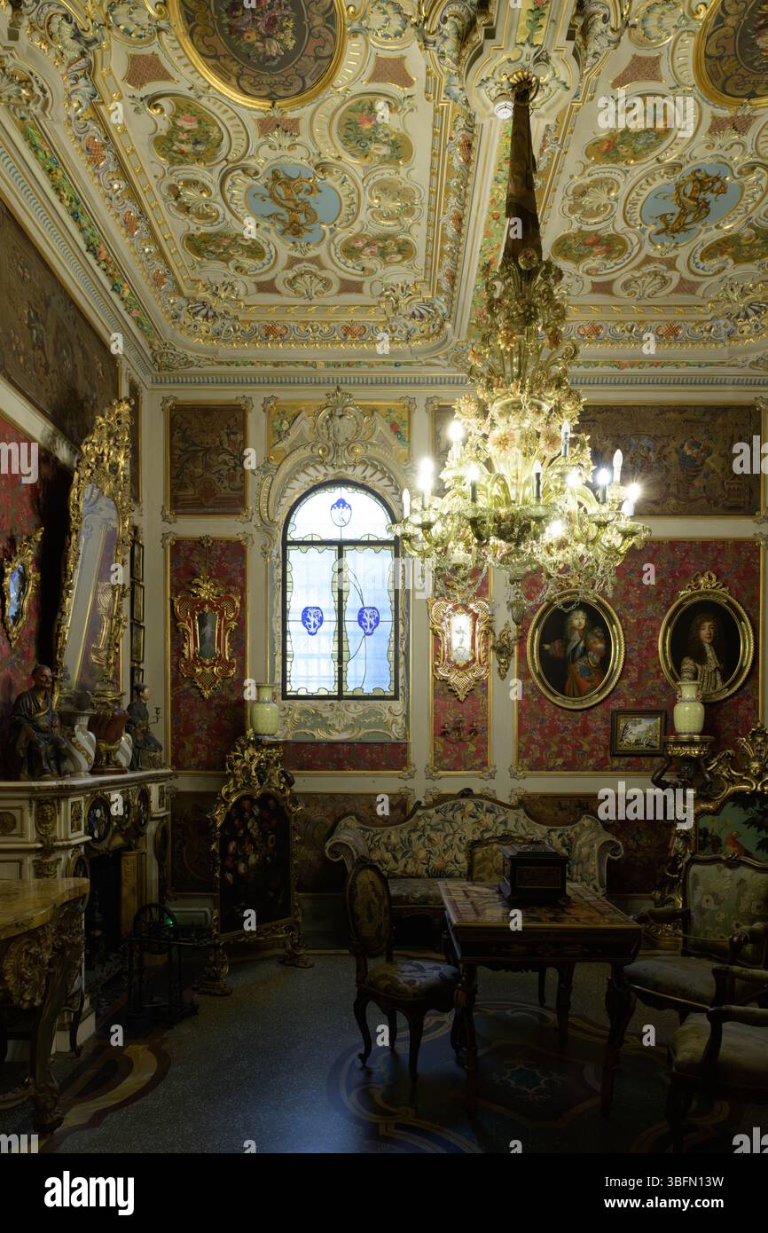 Großzügig eingerichtetes Zimmer im Stibbert Museum in Florenz, Italien, mit barocken Deckenfresken, Kronleuchtern und antiken Möbeln. Stockfoto