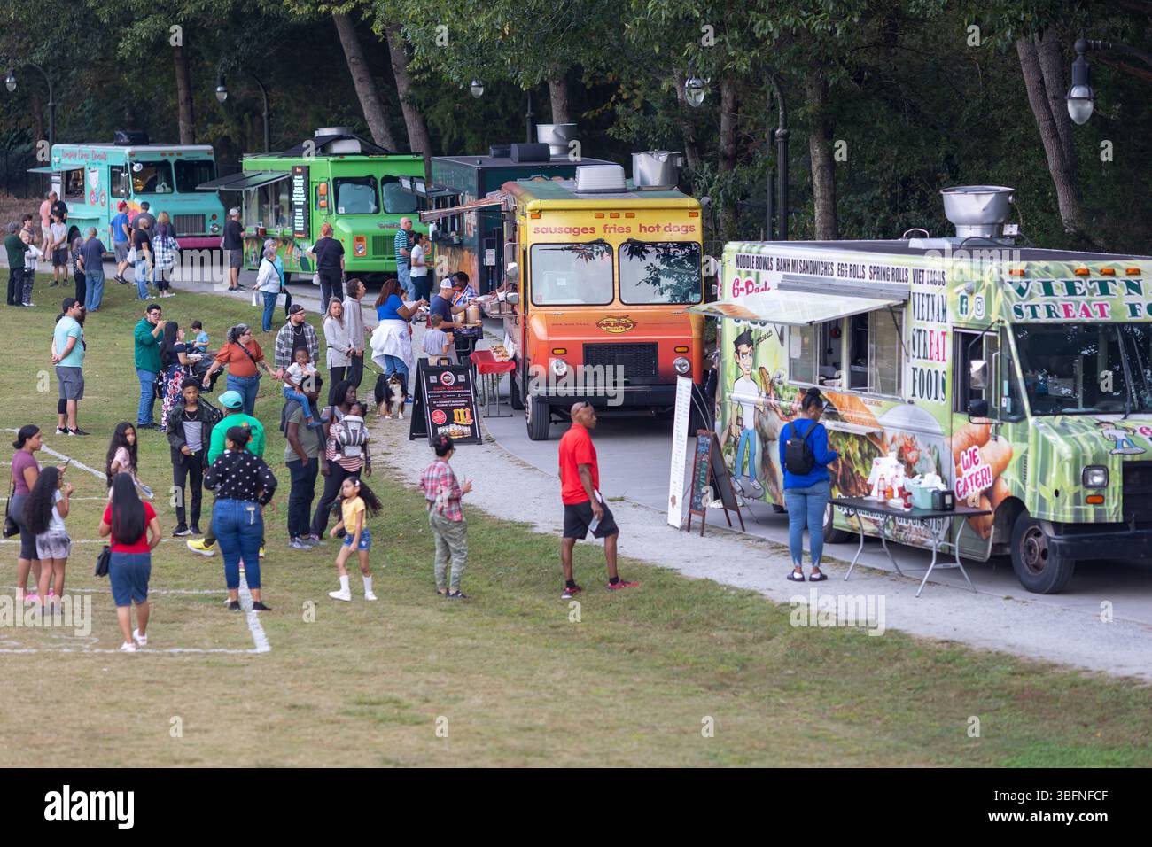 Lilburn, GA / USA - 10. Oktober 2023: In einem öffentlichen Park stehen die Menschen am 10. Oktober 2023 in Lilburn, GA, an fünf Food Trucks in einer Schlange. Stockfoto