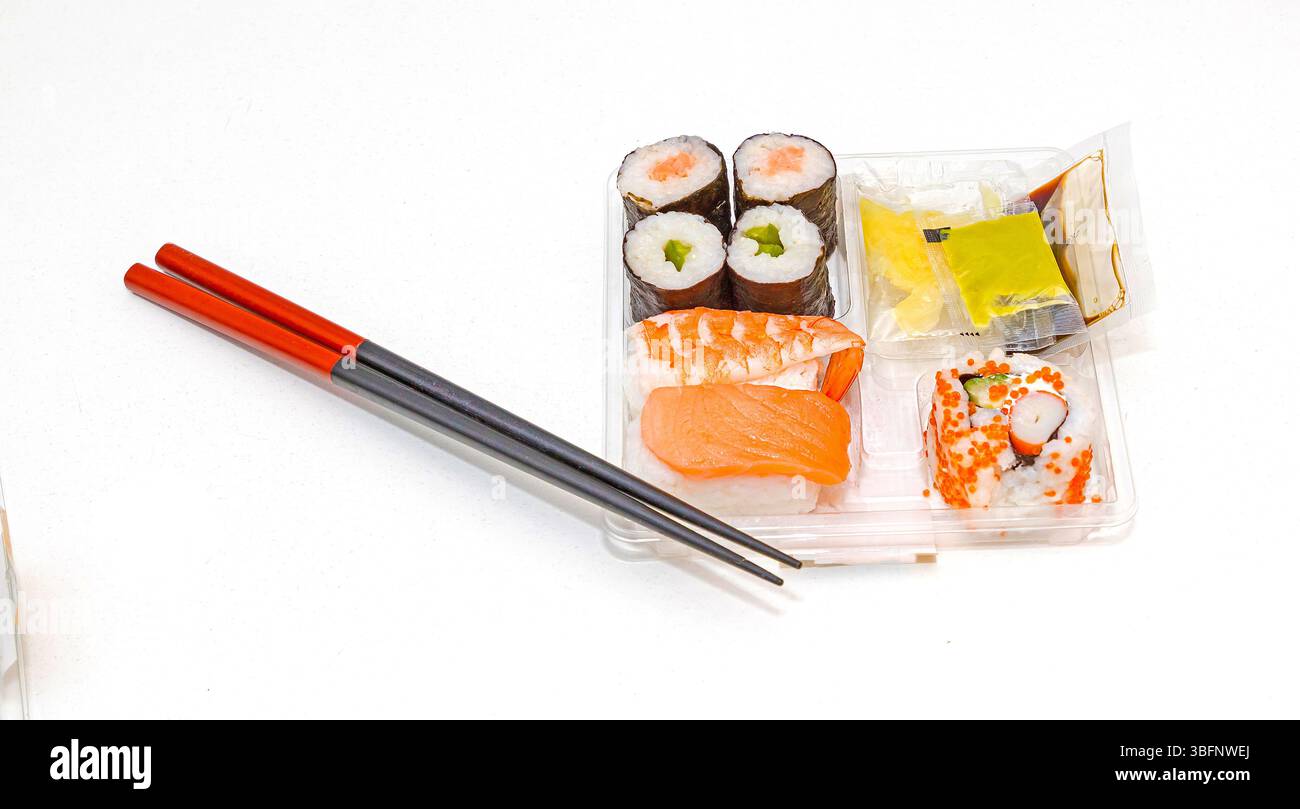 Traditionelles rohes Fisch Sushi und Sashimi in einer Plastikbox zum Mitnehmen mit Essstäbchen Stockfoto