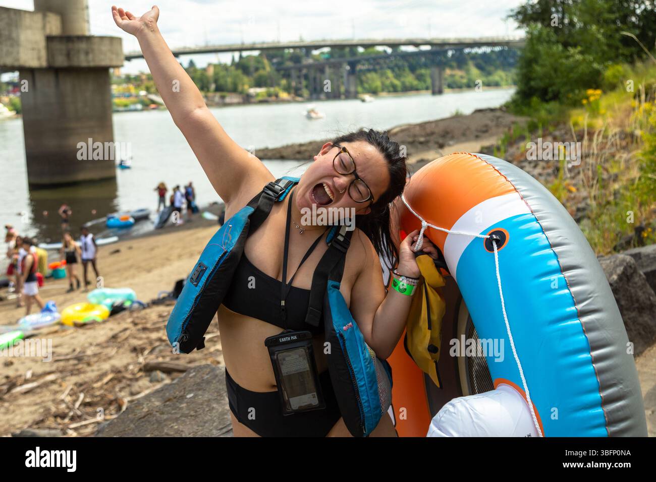 The Big Float, Portland, Oregon – 13. Juli 2019: Eine Frau jubelt mit ihrem Schwimmgerät, bereit, den Willamette River hinunter zu treiben. Stockfoto