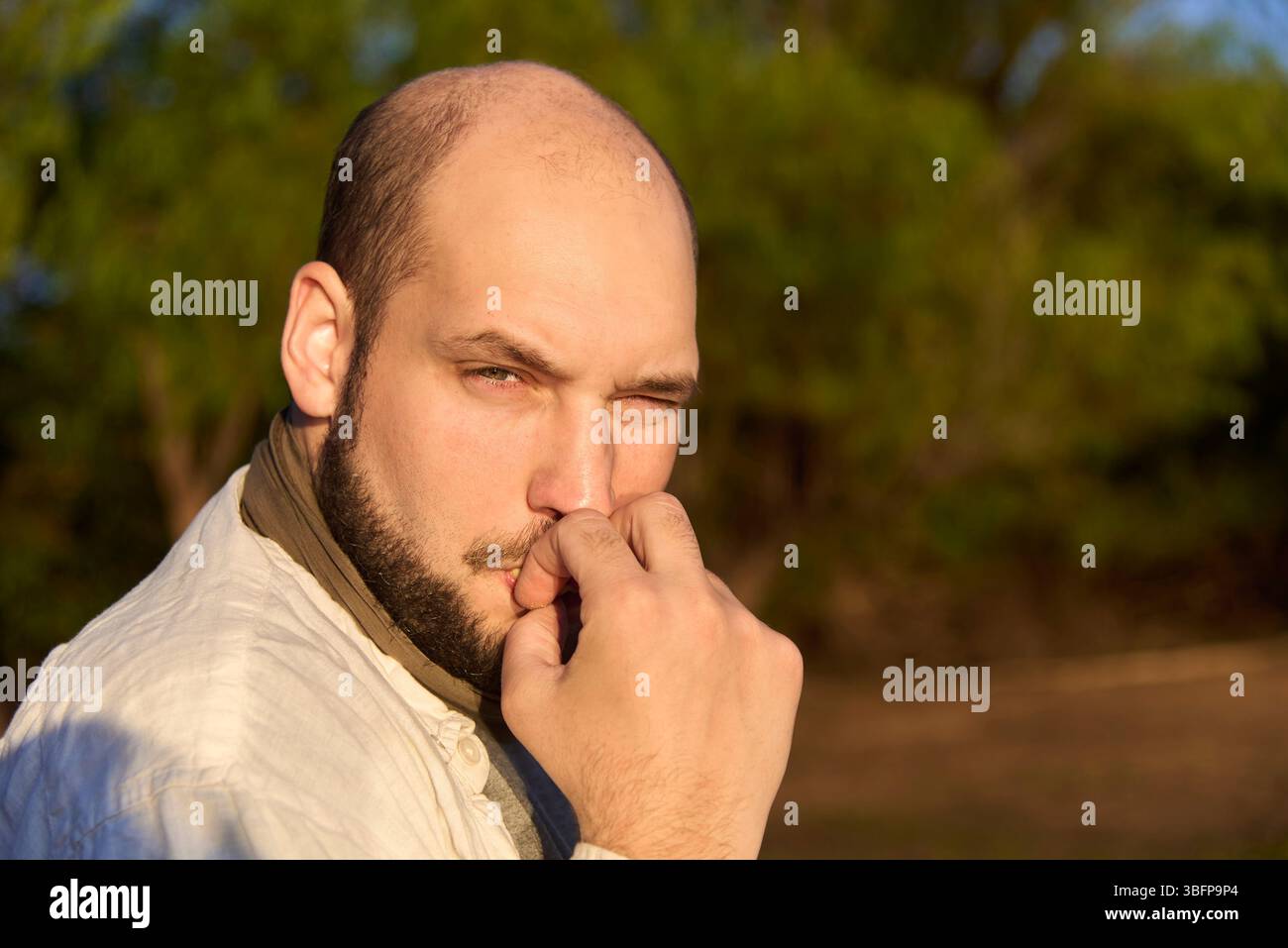 Hispanischer Reisender, der bei Sonnenaufgang am Ufer eines Baches sitzt und die ersten Sonnenstrahlen empfängt, während er gerne einen Keks isst. El Palmar National Stockfoto