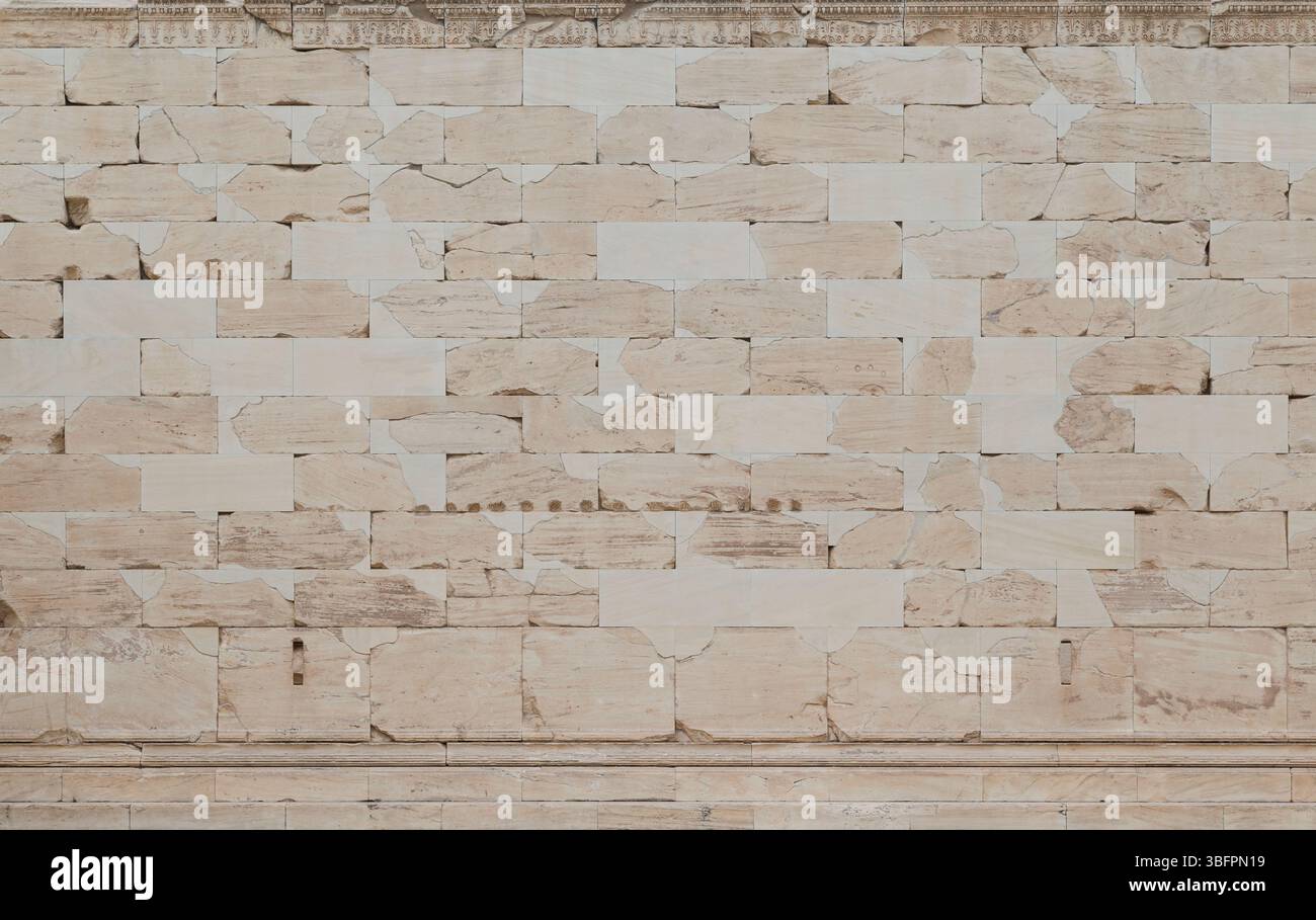 Glatte, verwitterte und rissige alte Mauer aus Steinblöcken in Athen, Griechenland, von vorne gesehen. Hochauflösender, strukturierter Hintergrund im Vollformat Stockfoto