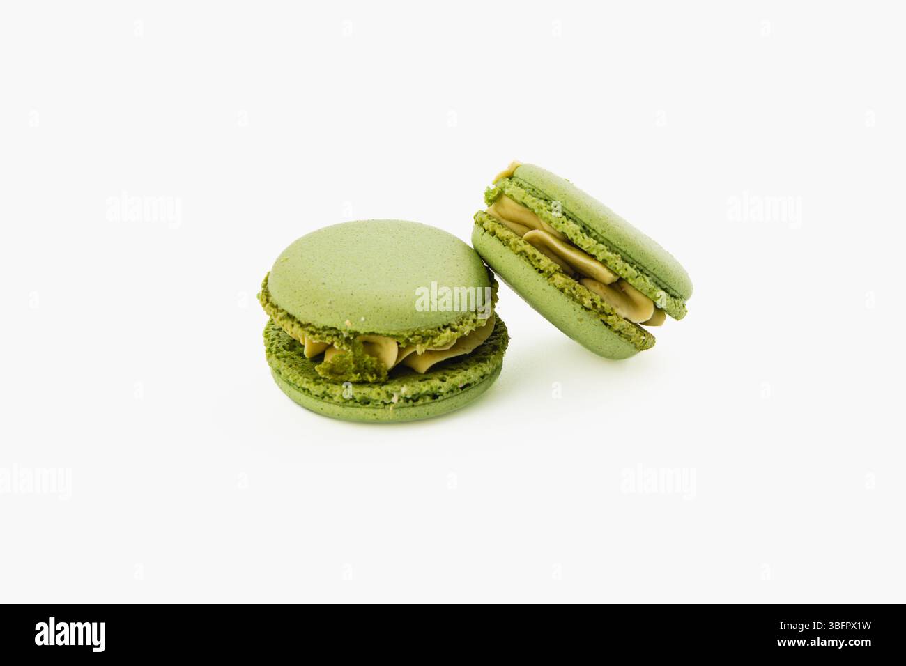 Köstliche grüne Macarons sind elegant in einem minimalistischen Ambiente angeordnet, mit ihrer glatten Textur und cremigen Füllung, perfekt für Dessert lov Stockfoto