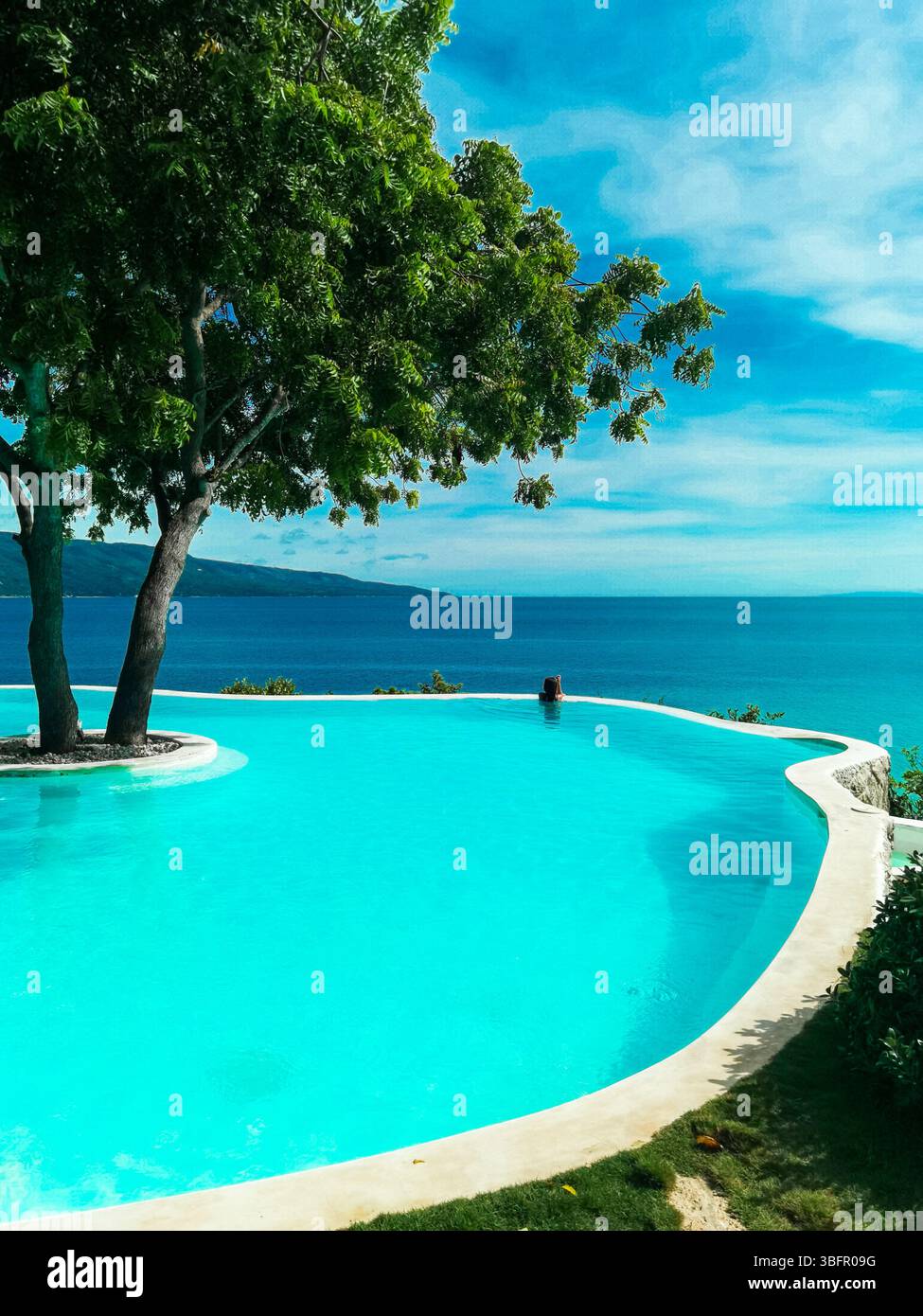 Türkisfarbenes, transparentes Wasser umgeben von üppigen Kiefern im idyllischen Sant Elm, Mallorca. Eine ruhige mediterrane Landschaft, die Ruhe, Frieden, - Smartphone-aufgenommenes Stockfoto