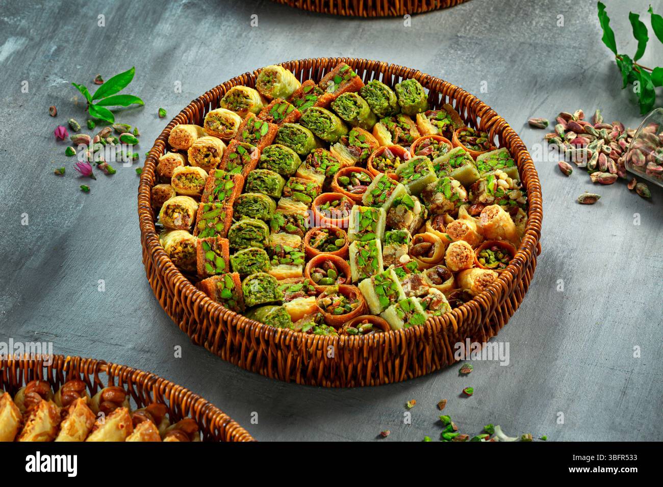 Gemischte Platte mit Pistazien-Baklava-Süßigkeiten, traditionelle arabische Desserts mit Ghee, heller Hintergrund Stockfoto