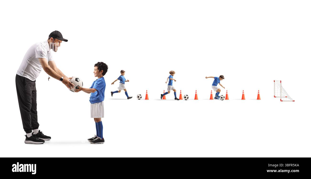 Fußballtrainer gibt einem Kind Fußball beim Training auf weißem Hintergrund Stockfoto