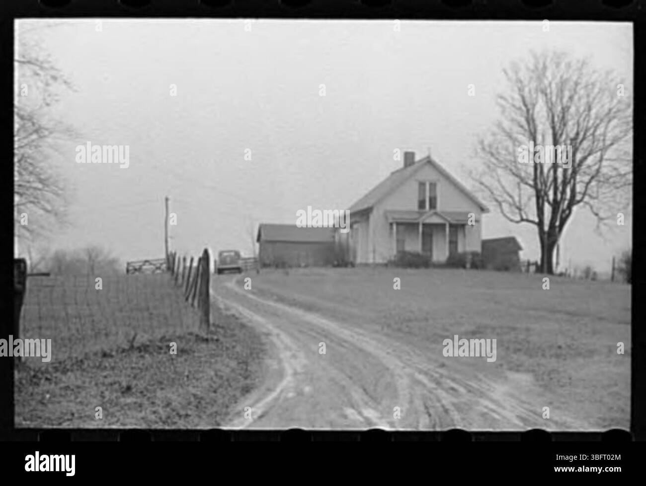 Eine allgemeine Ansicht eines ländlichen Bauernhofs, einschließlich offener Felder, eines Bauernhauses und landwirtschaftlicher Strukturen. Stockfoto