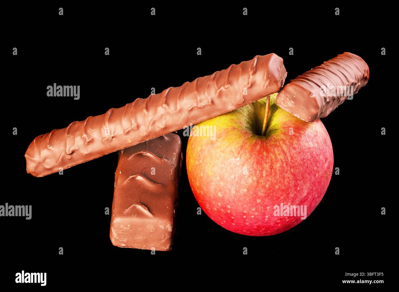 Gesunde Snackauswahl. Frisches Obst bietet eine bessere Auswahl als Schokoladentafeln. Stockfoto