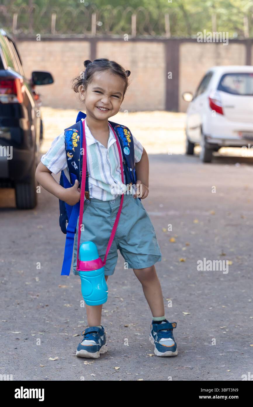indisches Kind süßer Ausdruck mit Betteln und Wasserflasche für den ersten Schultag an sonnigem Tag Stockfoto