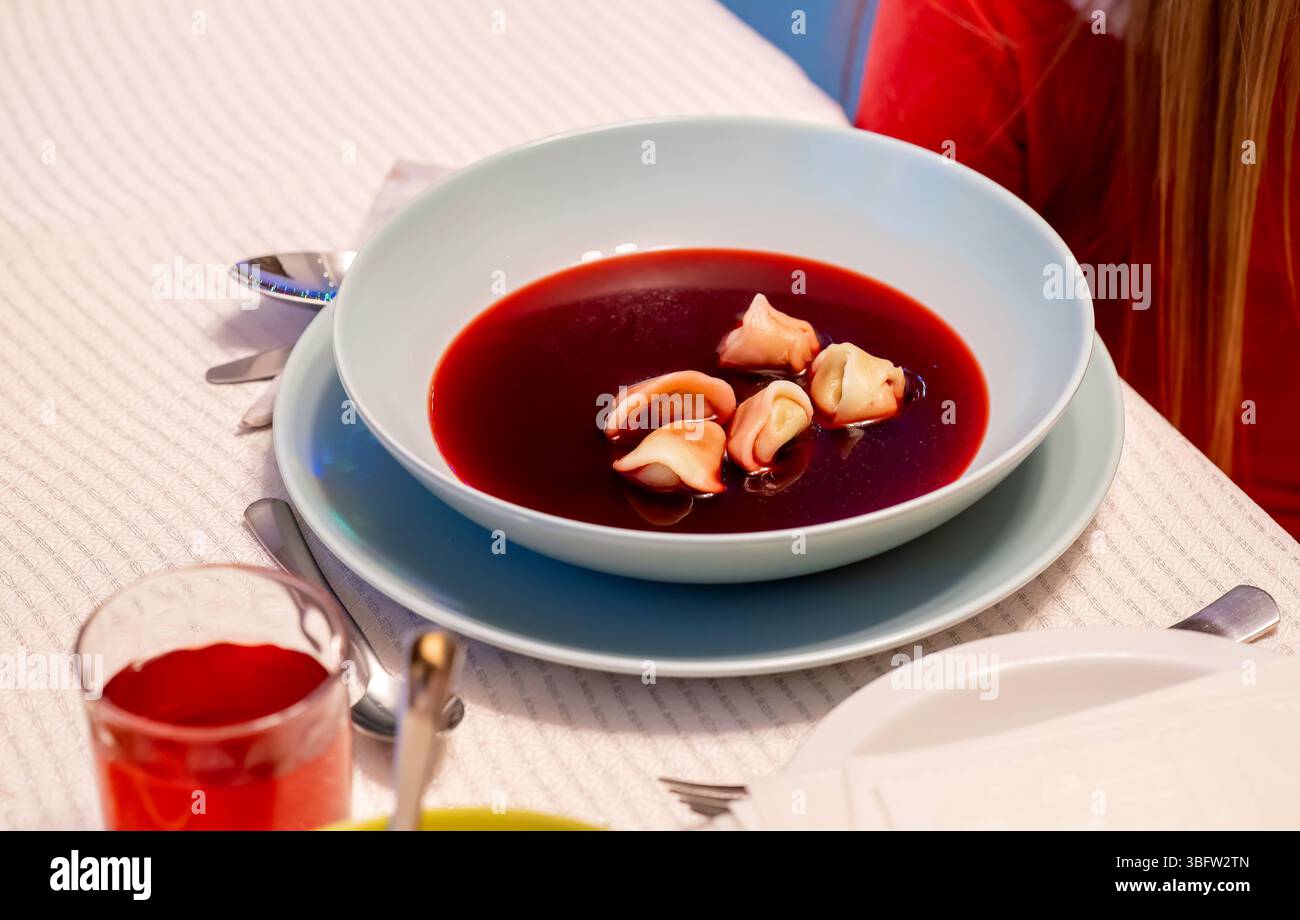 Traditionelle polnische rote Borschtsch-Rote-Bete-Suppe mit Knödeln serviert, festlicher Tisch, Barszcz Czerwony z uszkami Nahaufnahme des klassischen polnischen weihnachtsabends Stockfoto