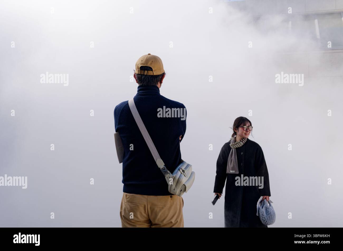 Zwei Museumsbesucher kreuzen die Wege im Nebel von Ryuichi Sakamoto’s Seeing Sound Stockfoto