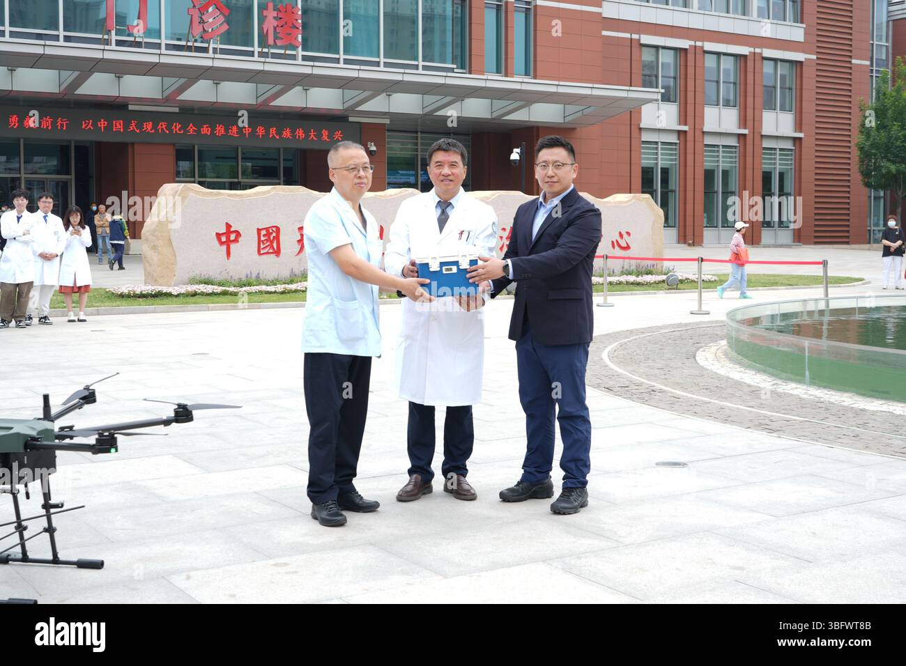 Tianjin. Juni 2025. Shen Jun (C), Vice President des Tianjin Medical University Cancer Institute and Hospital, erhält am 21. Mai 2025 eine Notblutversorgung durch eine Drohne während eines simulierten Testfluges in der Binhai-Niederlassung des Krankenhauses in Tianjin, Nordchina. ZU GEHEN MIT 'China Focus: Drohnen stärken Chinas medizinische Notfallsysteme' Credit: Xinhua/Alamy Live News Stockfoto