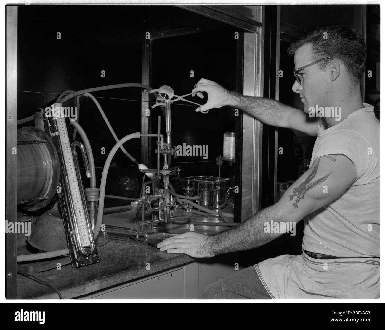 Wesley Smith füllt 1957 ein absolutes Manometer mit Quecksilber in der Abteilung Glasherstellung von Dow Chemical. Die 1925 gegründete Abteilung spezialisierte sich auf die Herstellung und Reparatur von Spezialglasgeräten, die im Werk Midland, Michigan, verwendet werden. Stockfoto