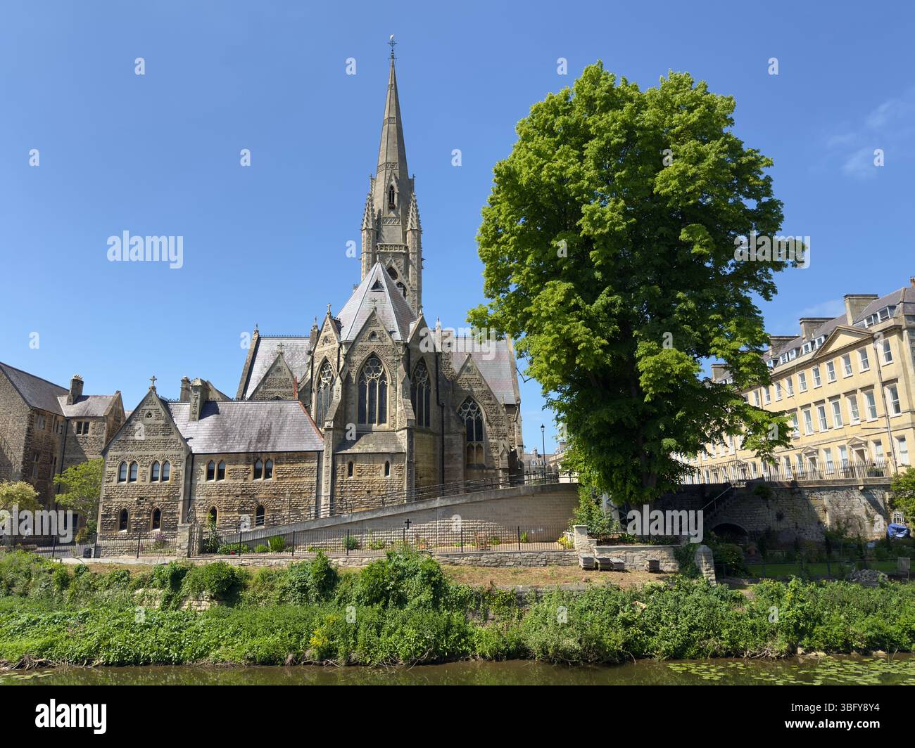 Bath, England – 17. Mai 2025: St. John the Evangelist's Church mit ihrem hohen Turm und ihrer historischen Architektur unter einem klaren blauen Himmel. - Smartphone-aufgenommenes Stockfoto