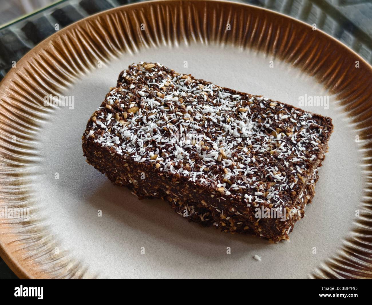 Hausgemachtes Dessert Rohschokolade Kokosnussscheibe auf einer Keramikplatte Stockfoto