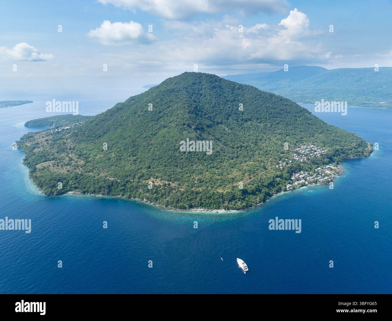 Die Vulkaninsel Rita entspringt der Pantarstraße bei Alor, Indonesien. Diese unverwechselbare Insel ist von artenreichen Korallenriffen umgeben. Stockfoto