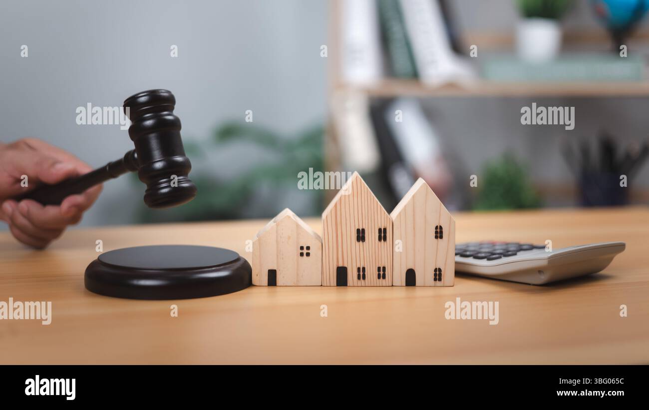 Hammer, Häuser, Taschenrechner. Symbolisiert Immobilienrecht, Immobilienauktionen, rechtliche Entscheidungen, finanzielle Bewertung. Ideal für Wohnungsmarkt, Hypotheken, in Stockfoto
