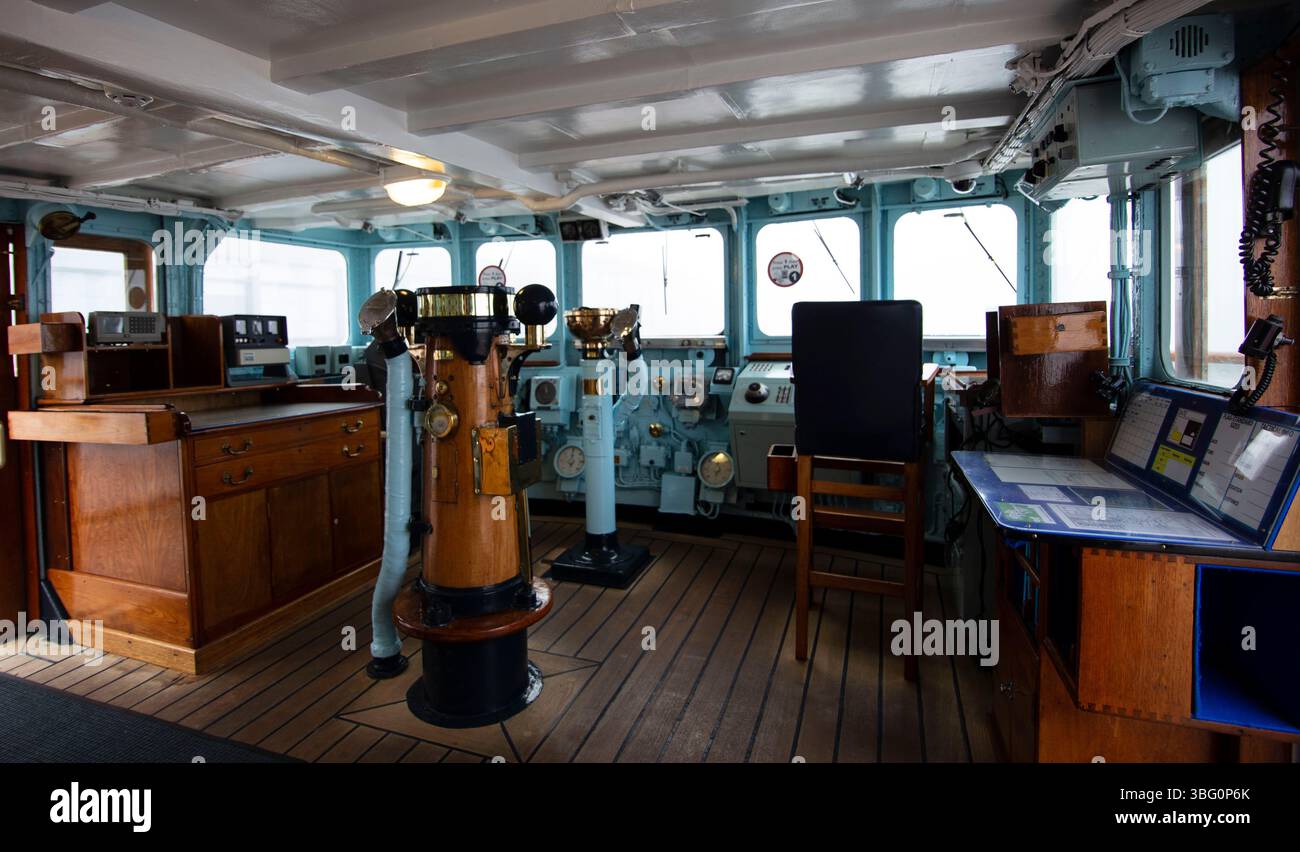 Innenansicht der Schiffsbrücke auf der Royal Yacht Britannia mit Navigationsausrüstung und Vintage-Holzmöbeln in maritimer Umgebung Stockfoto