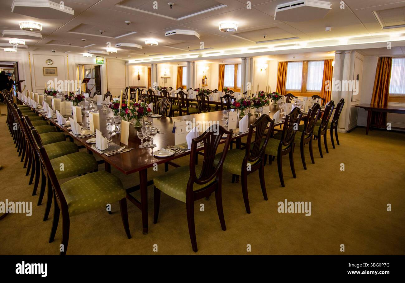 Eleganter Speisesaal auf der Royal Yacht Britannia für ein formelles Bankett mit langen Tischen mit Blumenarrangements und ordentlich ausgerichteten Stühlen Stockfoto