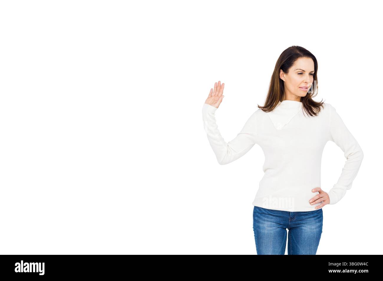 Reife Frau, die die rechte Hand nach außen hebt, den linken Arm auf der Hüfte im Fotostudio, im Kopierraum Stockfoto