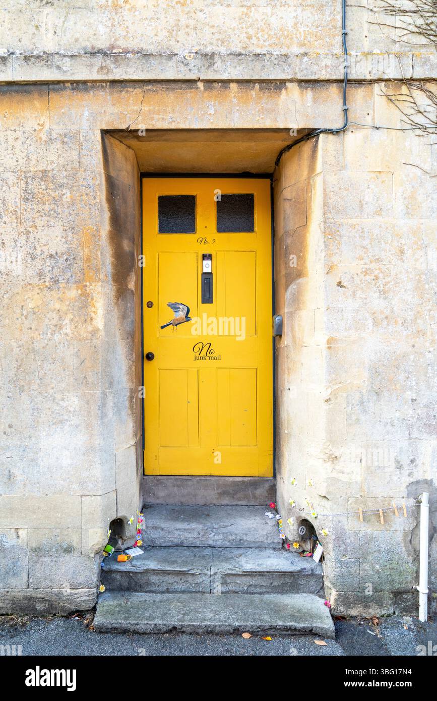 Steingebäude mit gelber Tür und einem Bild eines Vogels Stockfoto