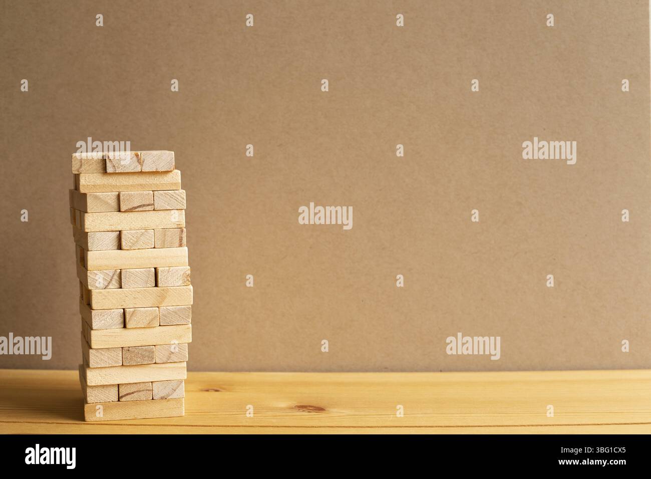 Jenga Holzblock Turm mit braunem Hintergrund. Block Stack Spiel. Geschäftsrisiko, Entwicklung, Wachstum, Strategiekonzept. Mit Kopierplatz Stockfoto
