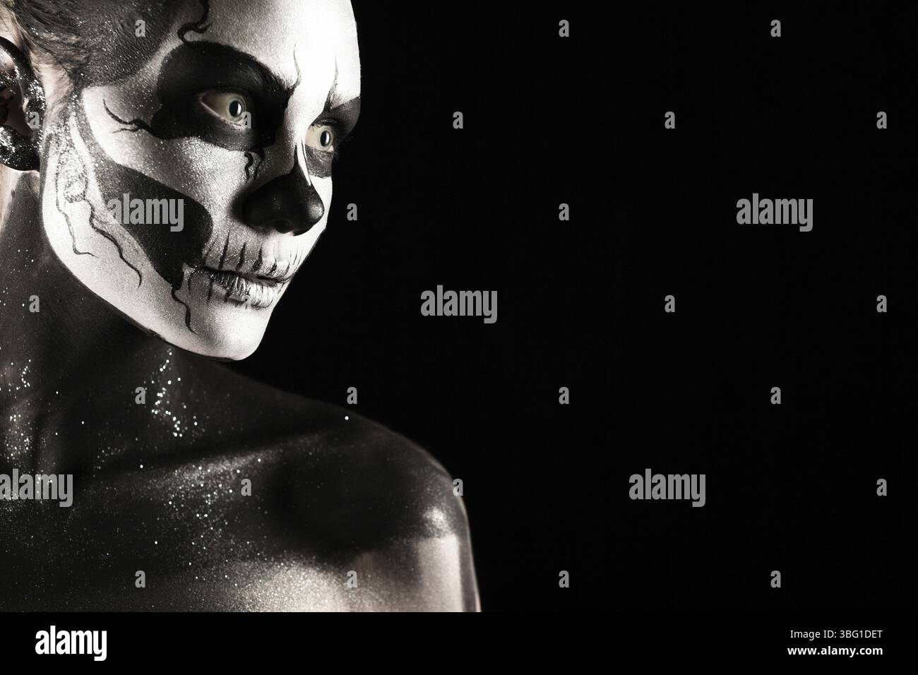 Isoliert auf schwarzem, Nahaufnahme Bild, schöne junge blonde weiße Frau mit Schädelkörperkunst, grauen Augen, Position links, Blick rechts Stockfoto