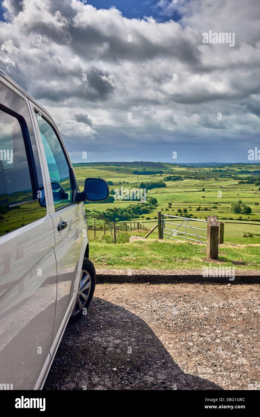 Ein weißer Volkswagen Transporter T6.1 parkt an einem Aussichtspunkt in Bretton, Derbyshire, Peak District National Park mit Blick nach Süden über die Derbyshire Dales. Stockfoto