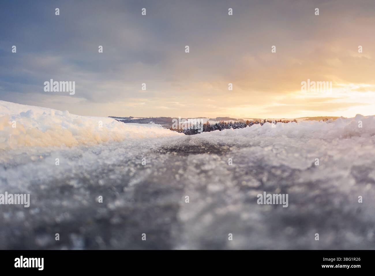 Blick auf die vereiste Straße von der Bodendrohne vor dem Start bei Sonnenuntergang Stockfoto