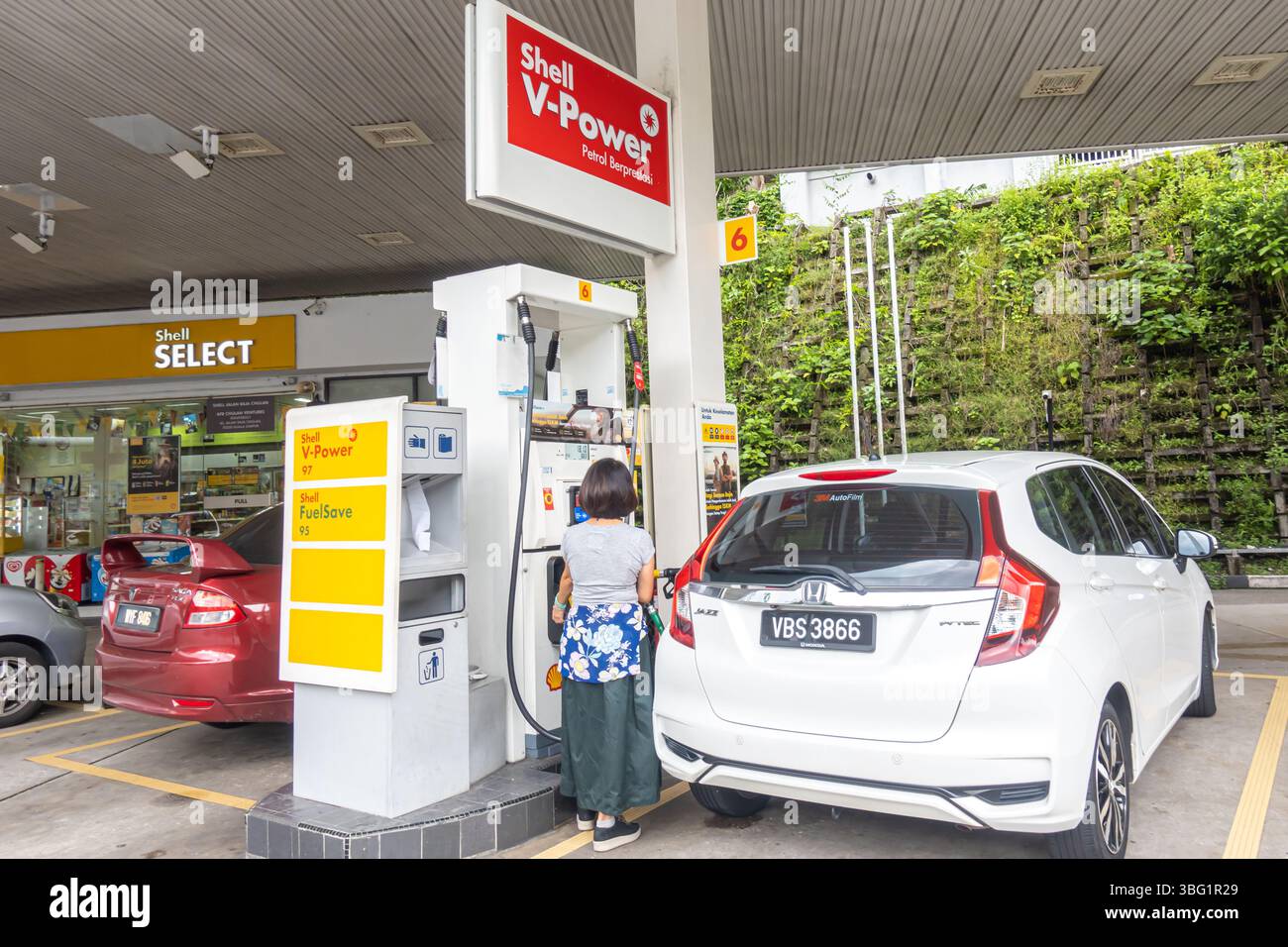 Kuala Lumpur. Frau betankt einen weißen Honda Jazz an einer Shell-Tankstelle mit Shell V-Power, einem erstklassigen Kraftstoff zur Verbesserung der Motorleistung Stockfoto