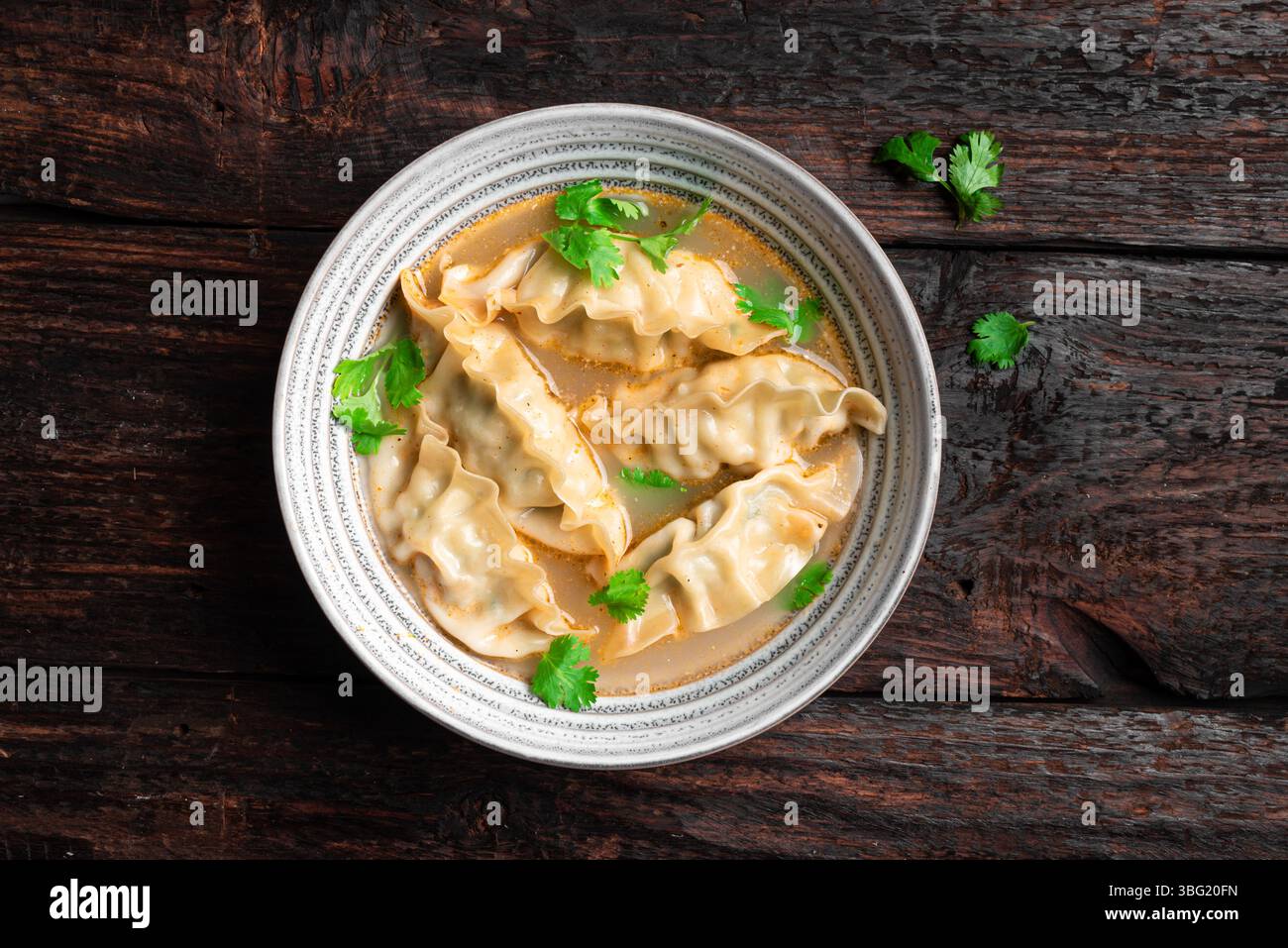 Wonton Suppenschüssel. Garnelen- oder Schweinefleisch-Wonton-Suppe mit Ciliantro, Blick von oben. Asiatisches Mittagessen - Knödelsuppe. Stockfoto