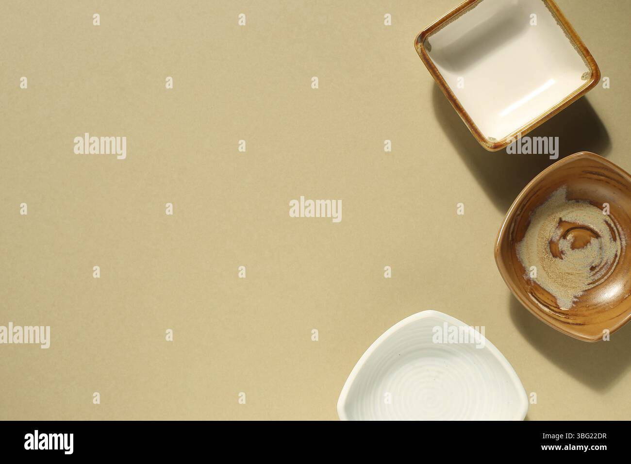 Leere Schale und Schüssel auf beigen Hintergrund Stockfoto