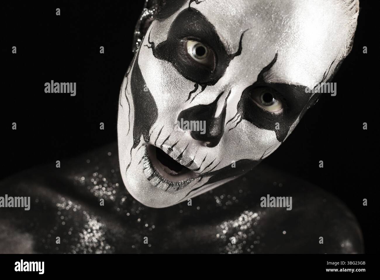 Isoliert auf schwarzem, Nahaufnahme Bild, schöne junge blonde weiße Frau mit Schädelkörperkunst, grauen Augen, durchdringendem Blick, gedreht Stockfoto