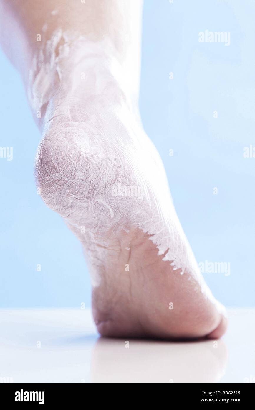 Pflege für trockene Haut an den gepflegten Füßen und Fersen mit Cremes für Haut und Füße Stockfoto